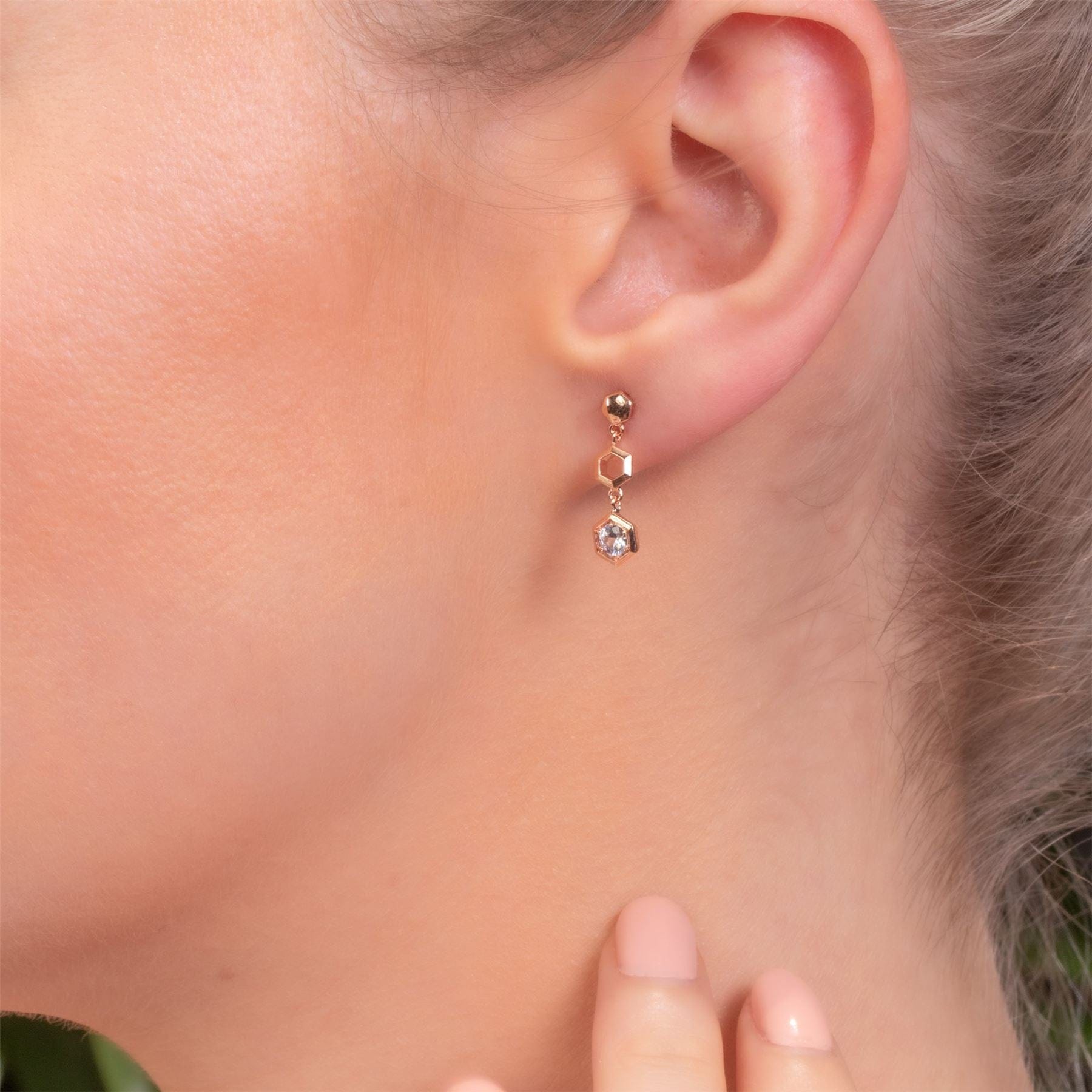 Honeycomb Inspired Clear Sapphire Drop Earrings in 9ct Rose Gold on Model